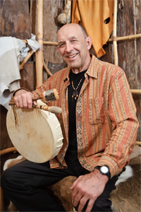 Joseph Bruchac smiling and holding a hand drum.