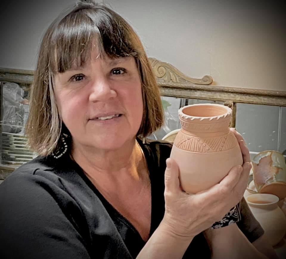 Vicki Blanchard holding pottery.
