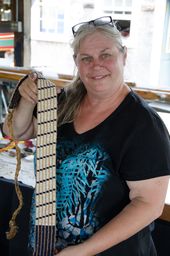 Linda Longtoe Sheehan holding up a wampum belt she made.