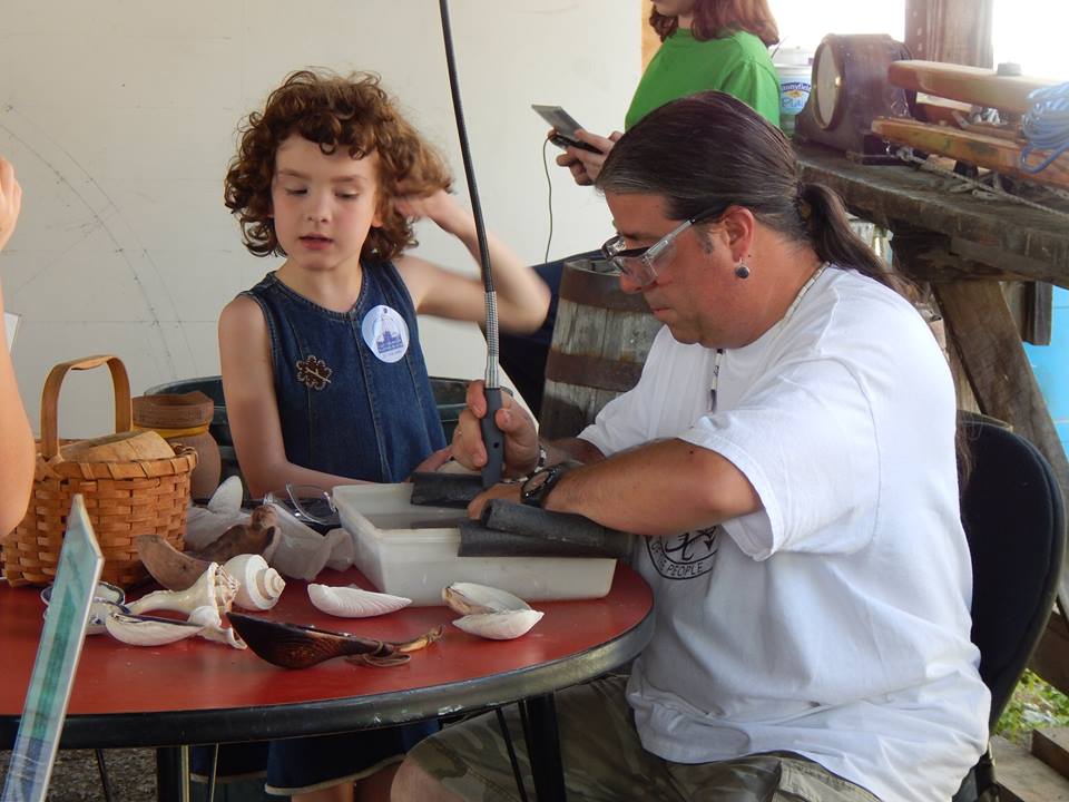 Man working on art project with child looking on.
